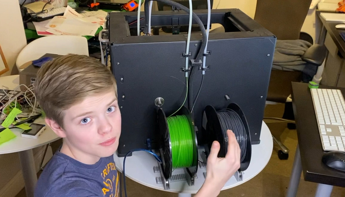 boy with qidi tech 1 3d printer