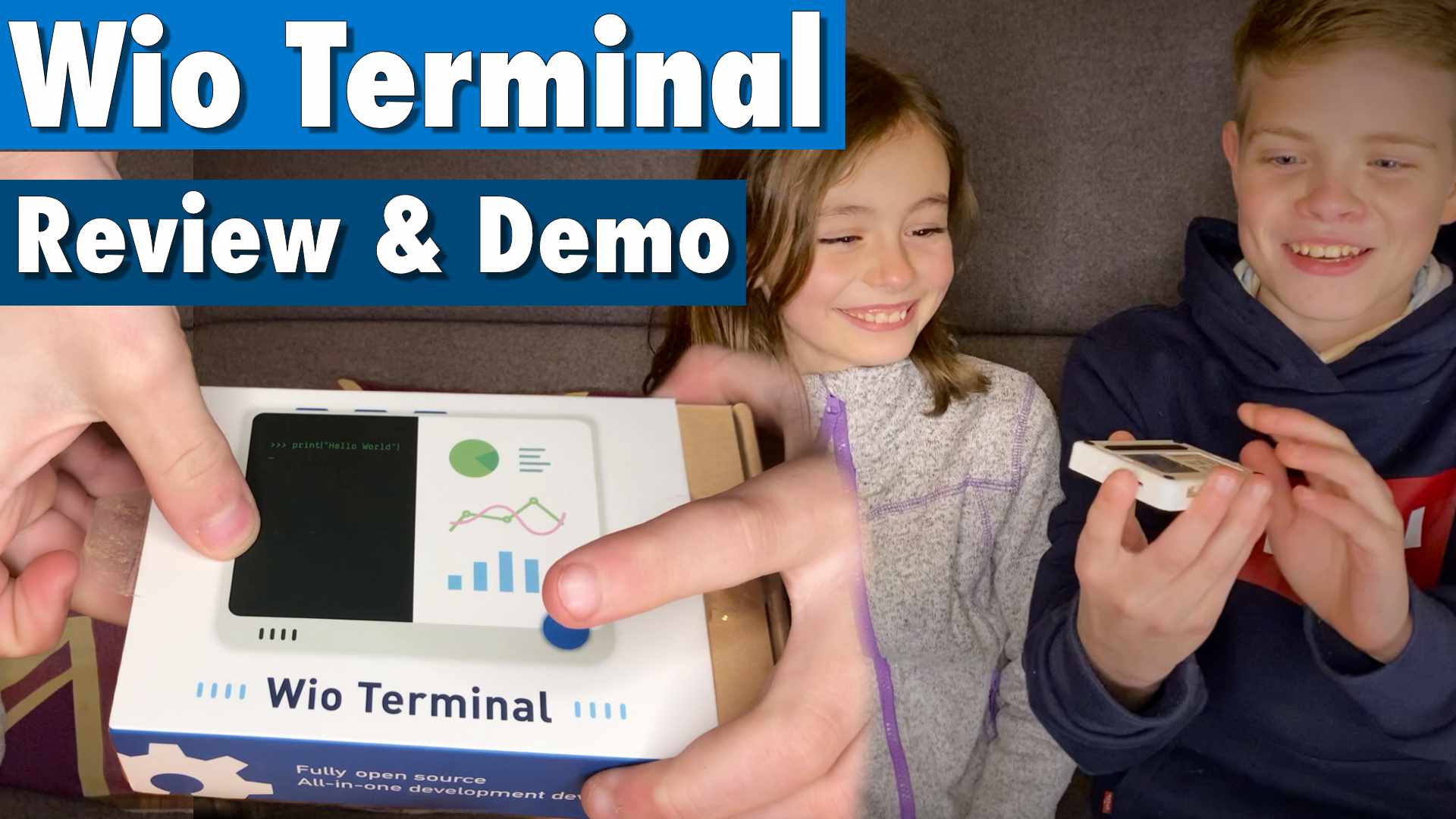 Boy and girl holding wio terminal with an image of the wio terminals box next to them